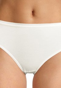 Brasiliana bianca in cotone con una texture liscia, una cintura morbida e un taglio classico. Il tessuto appare leggero e traspirante.