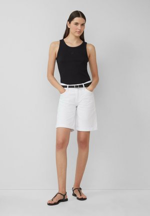 Débardeur noir à côtelés, short blanc longueur genou avec ourlets, ceinture noire avec boucle en métal, et sandales plates noires, présentées sur un fond gris.