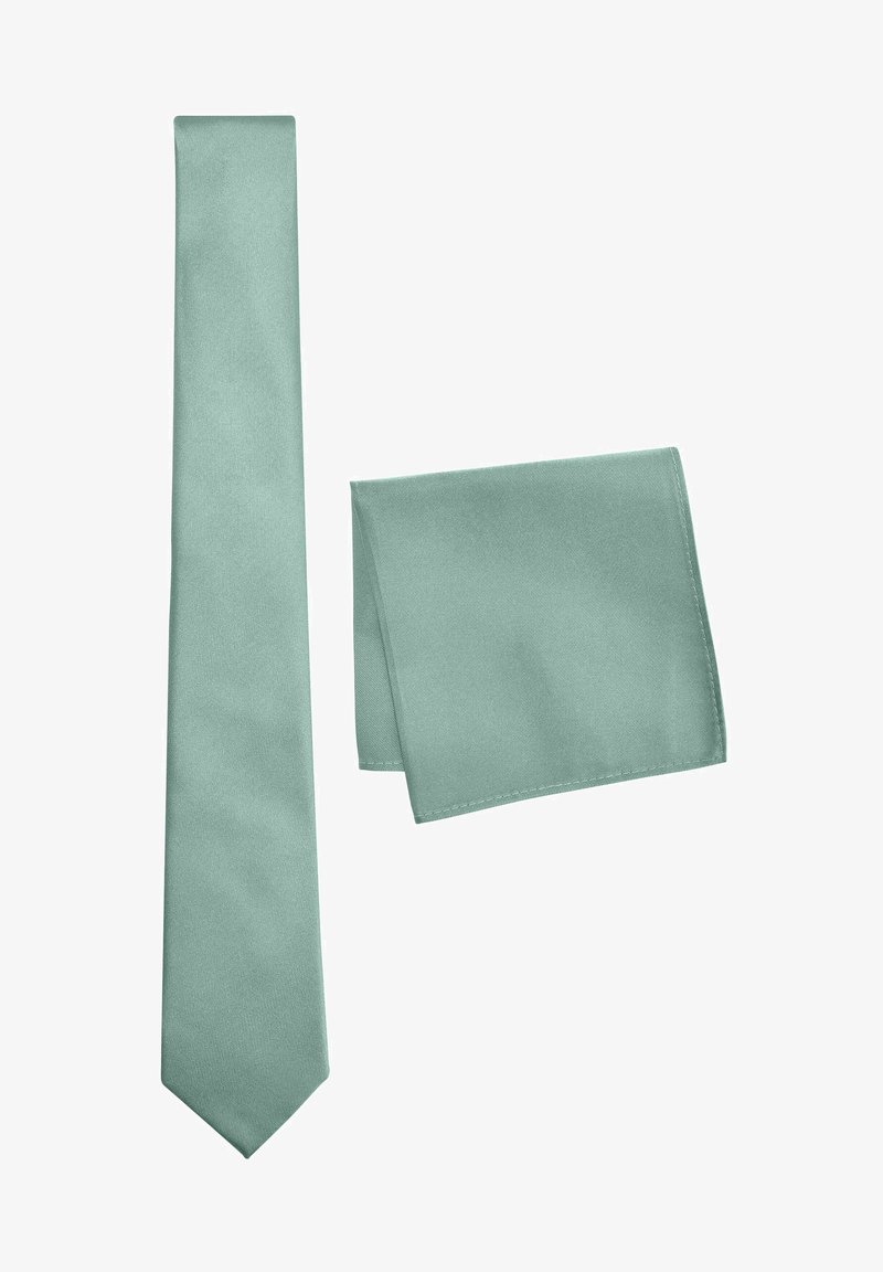Cravate en soie vert clair et pochette assortie, présentant une texture lisse et une couleur unie sans motifs ni embellissements.