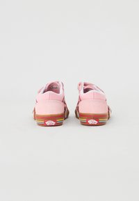 Baskets en daim rose avec une semelle à rayures arc-en-ciel. Les caractéristiques incluent un col rembourré, une étiquette de logo et une conception à bout arrondi.
