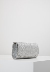 Clutch argentato con un design rettangolare, superficie liscia e una semplice chiusura a patta. Presenta un sottile accento argento sul bordo.