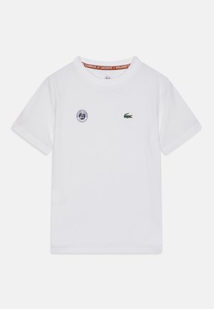 White cotton t-shirt with short sleeves, featuring a round neckline, green crocodile logo, and a small blue circular emblem on the chest.