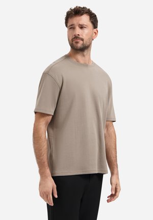 Kurzarm-T-Shirt mit Rundhalsausschnitt aus leichtem beige Baumwollstoff. Verfügt über einen lockeren Schnitt und eine glatte Textur, mit sichtbaren Nähten entlang der Nähte.