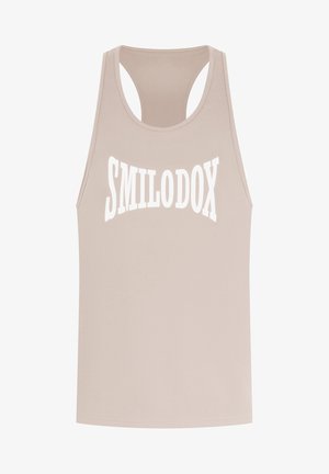 Beige tanktop med rund halsudskæring og racerback-design. Har iøjnefaldende, hvid "SMILODOX" tekst på forsiden. Glat stofstruktur.