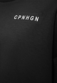 Black cotton t-shirt featuring the white text "CPNHGN" printed on the front. Smooth texture, crew neck design, and short sleeves.