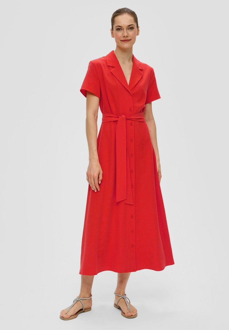 Rotes Midi-Kleid mit kurzen Ärmeln, eingeschnittenem Kragen, Gürtel und Knopfverschluss vorne. Glattes Material mit fließender Silhouette.