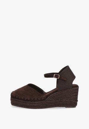 Espadrille cuña marrón con punta cerrada, correa en el tobillo con hebilla dorada y suela de yute trenzado.