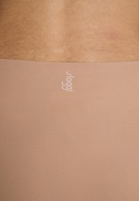 Helle beige nahtlose Unterwäsche mit einer weichen Textur. Verfügt über ein dezentes weißes "sloggi"-Logo am Bund. Glattes, figurnahes Design.