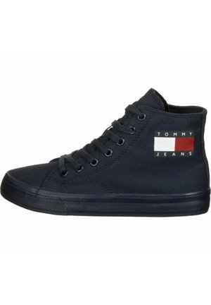 Czarny wysokoprofilowy tenisówka z płótna z czarnymi sznurowadłami, gumową podeszwą oraz logo Tommy Jeans w kolorach białym, czerwonym i czarnym po bokach.