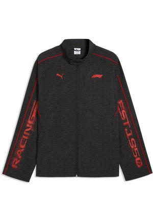 Sort lynlåsjakke med røde Puma- og F1-logoer på brystet, røde piping-detaljer på skuldre og ærmer samt teksten "RACING" og "QST.50" på ærmerne.