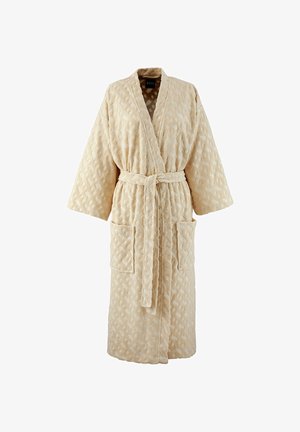 Accappatoio beige testurizzato con maniche lunghe, due tasche frontali e cintura abbinata annodata in vita.