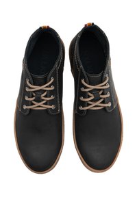 Zwarte leren schoenen met beige veters, een bruine zool en een blauwe en oranje accent aan de achterkant. Gladde textuur en een klassiek ontwerp.