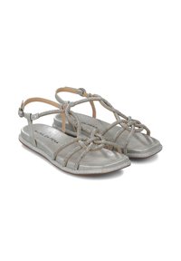 Sandalias planas plateadas con correas trenzadas y un detalle de nudo, con un acabado metálico suave y una suela texturizada y brillante.