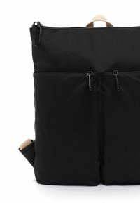Czarny prostokątny plecak z dwoma przednimi kieszeniami zapinanymi na zamek, beżowy uchwyt na górze oraz częściowo widoczne regulowane paski na ramiona.
