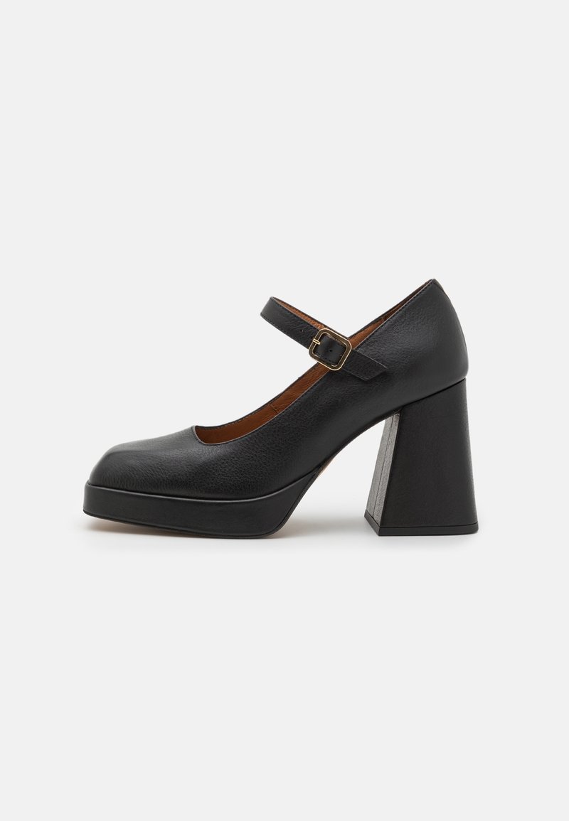Chaussure Mary Jane en cuir noir avec un bout arrondi, une bride à boucle réglable et un large talon bloc sur un fond uni.