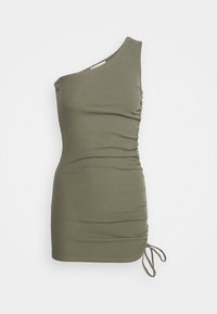 Top olive vert à une épaule avec texture côtelée, présentant un ruché sur le côté et des liens ajustables à l'ourlet. Design ajusté.