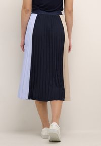 Plisovaná midi sukně s čtyřmi barevnými panely: navy, světle modrá, béžová a tmavší odstín. Design má hladkou texturu a elastický pas.