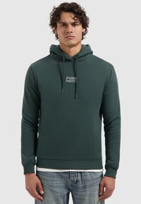Donkergroene hoodie van zacht materiaal, met een kangoeroezak, geribde manchetten en koordjes. "PURE PATH" logo op de voorkant.