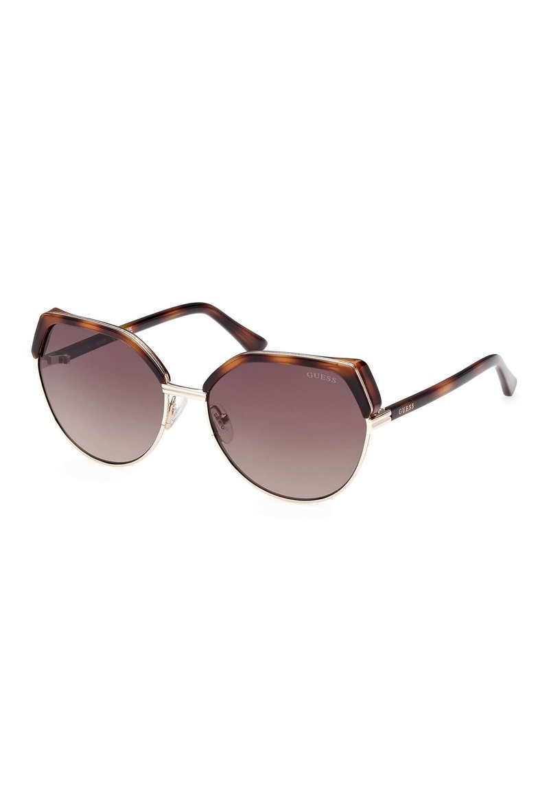 Gafas de sol estilo cat-eye con un marco de carey marrón, herrajes plateados y lentes degradados. Presentan una forma angular distintiva y patillas gruesas.