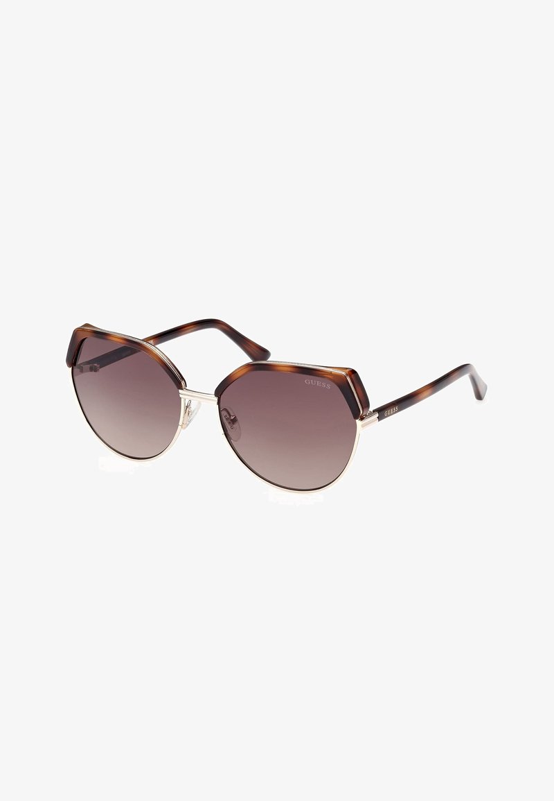 Cat-eye sunglasses with a brown tortoiseshell frame, silver hardware, and gradient lenses. Features distinctive angular shape and thick temples.