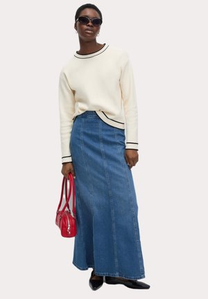 Cream sweatshirt with black trim, paired with a long blue denim skirt. Accessorized with a red handbag and black pointed shoes.