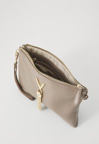 Beige leather clutch bag with gold hardware, zip closure, and tassel detail; features an interior pocket and a wrist strap.