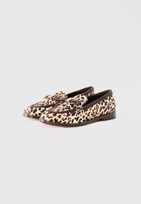 Et par leopardmønstrede loafers med brun kant og dekorative frynser på en hvit bakgrunn.