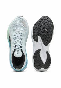 Világoskék sportcipők, hálós felső résszel, fekete díszítéssel és fehér gumitalppal, amely textúrázott mintával rendelkezik. Fűzős kialakítás.