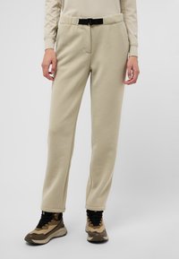 Tan, zachte fleece sweatpants met een aansluitende tailleband en voorzakken, voorzien van een zwarte verstelbare riem en een rechte pijpdesign.