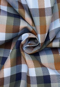 Geruite stof in blauw, bruin en beige. Heeft een gestructureerd patroon met diagonale strepen en een glanzende uitstraling. Geschikt voor verschillende toepassingen.