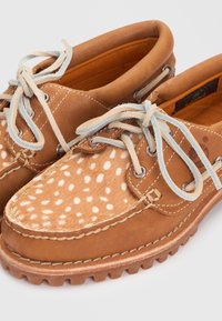 Καφέ δερμάτινα boat shoes με λευκή πουά γούνα στην κορυφή, γαλάζια σουέντ κορδόνια και ανθεκτικές καουτσούκ σόλες.