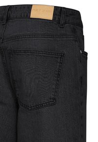 Jean en denim noir vue arrière montrant la poche arrière droite et un patch en cuir marron de la marque Pulz Jeans.