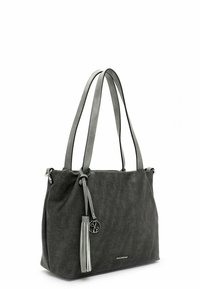 Sac en tissu gris avec deux poignées, accent en frange et un pendentif circulaire. Texture lisse avec une forme structurée.