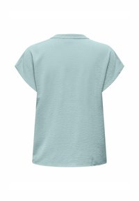 Top de manga corta azul claro con una tela texturada, que presenta un escote redondo y un corte relajado sin cierres ni patrones visibles.