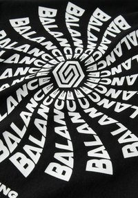 Tela negra con un diseño en espiral que presenta la palabra "BALANCE" en letras blancas en negrita, creando un patrón dinámico con un hexágono central.