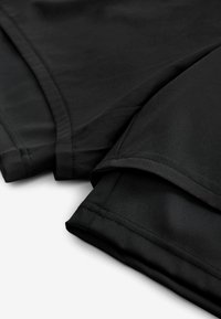Tissu textile noir plié, présentant une texture lisse et des coutures propres. Le design ne comprend aucun motif ni matériel visible.