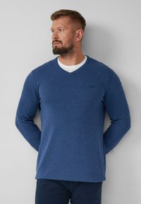 Marineblauer Pullover mit langen Ärmeln und V-Ausschnitten, aus weichem Strickmaterial gefertigt, mit einem kleinen Logo auf der Brust und gerippten Bündchen.