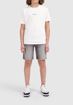 Witte T-shirt met korte mouwen met de tekst "BALLIN'", gecombineerd met grijze denim shorts en witte sneakers met zwarte accenten. Eenvoudig ontwerp, casual pasvorm.