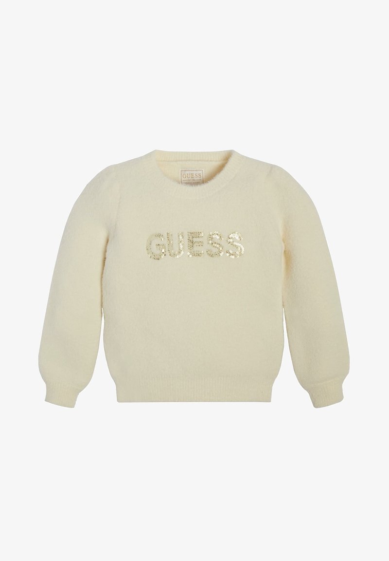 Pull à manches longues de couleur crème avec poignets et ourlet côtelés, orné de "GUESS" en sequins dorés sur la poitrine.