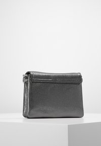 Borsa a tracolla grigia metallica con finitura texturizzata, chiusura a pattina e un piccolo dettaglio in metallo argentato sul lato. Forma rettangolare compatta.