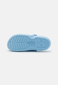 Suola di scarpa in gomma blu chiaro con motivo a rilievo testurizzato, inclusi sezioni sollevate e branding. Superficie liscia e design del tacco arrotondato.