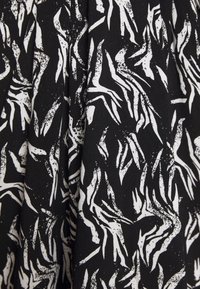 Svart tyg med ett upprepat abstrakt vitt mönster som liknar penseldrag; textilen verkar slät med en lätt glans.