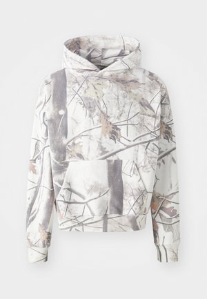 Kapuzensweatshirt im Camouflage-Muster mit Zweigen und Blättern in Grau, Weiß und gedämpften Erdtönen. Mit einer Fronttasche.