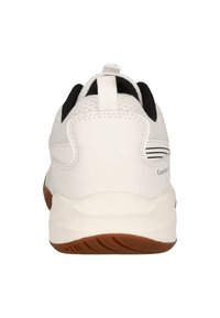 Vit idrottssko med mesh-överkänsla, svarta accenter, vadderad krage och en brun gummisula; har en dragöppning för enkel påtagning.