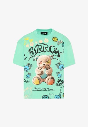 Maglietta a maniche corte verde menta con illustrazione di un orsetto di peluche, testo in stile graffiti nero e colorati teschi e impronte di zampa in stile cartone animato.