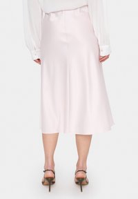 Ljusrosa satin midi kjol med en slät textur, utsvängd design och en subtil lyster. Har en slits bak för ökad rörelsefrihet.