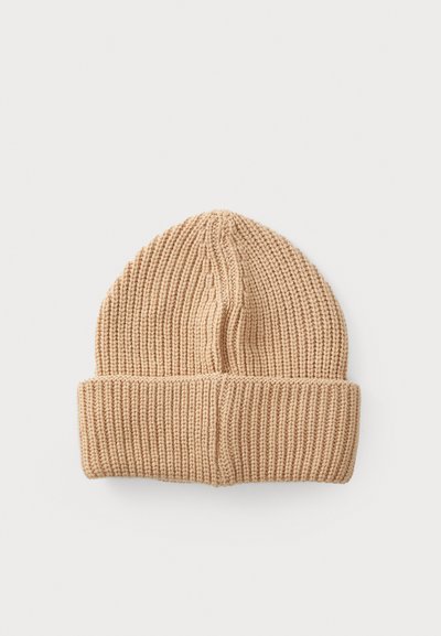 Berretto a maglia di colore beige chiaro con una texture a coste. Presenta un risvolto e una punta, realizzato in materiale morbido e elasticizzato.
