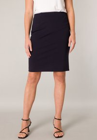 Knielange kokerrok in donkerblauwe stof, met een strak ontwerp, gladde textuur en aansluitende pasvorm.
