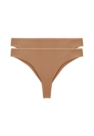 Deux pièces de sous-vêtements string beige sans couture empilées, montrant un tissu lisse et des coutures minimales sur fond blanc.