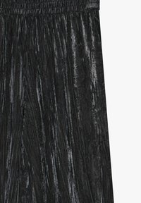 Sort plisseret stof med en skinnende, tekstureret overflade. Elastisk talje øverst. Overfladen viser lodrette linjer, der skaber en stribet effekt.